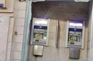 بالصورة...صاحب احدى البسطات يحطم صراف آلي تابع لأحد البنوك بـ"البلطة" في الزرقاء
